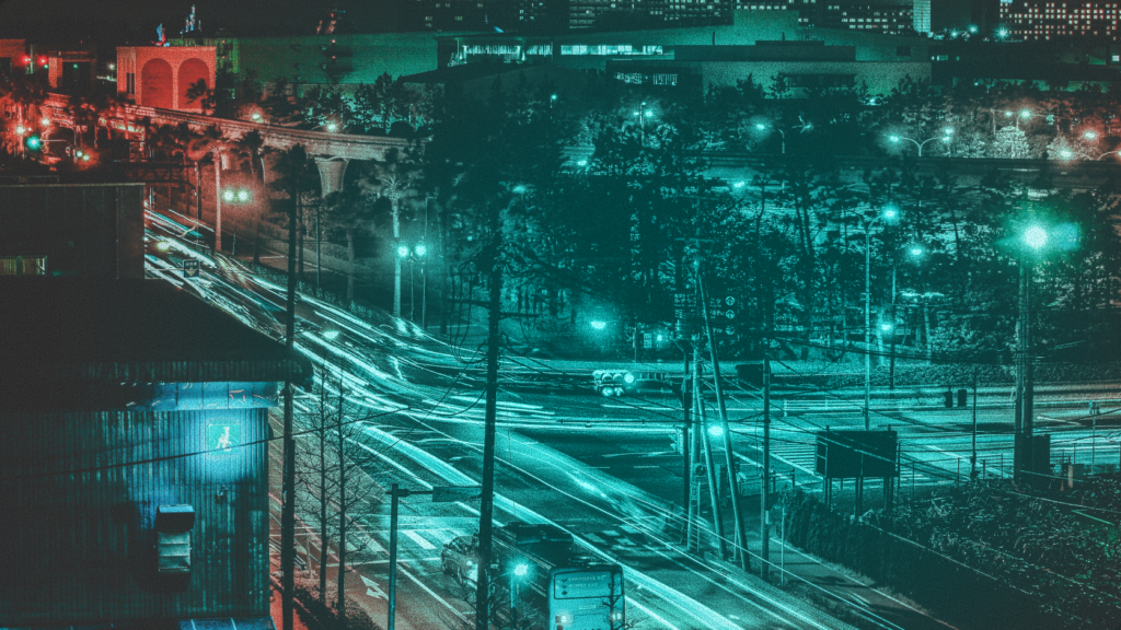 Long exposure photo of night city traffic on an Abuja highway with cyan and teal lighting, symbolizing fast, compliant cross-border financial data flows across African capital markets
