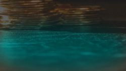 Stacked metallic coins reflecting over a dark teal fluid surface, representing digital liquidity, global asset reserves, and stablecoin payment infrastructure
